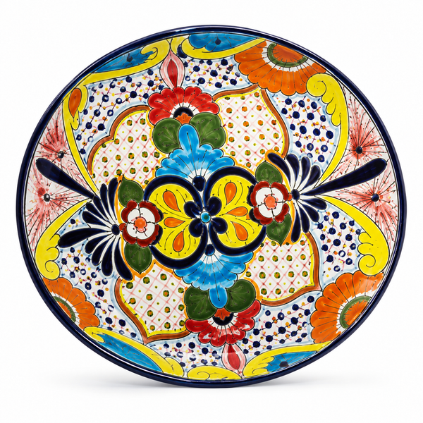 A round hand-painted ceramic plate with a vibrant, symmetrical Mediterranean style pattern featuring yellow, blue, orange, red, and green motifs on a white background.